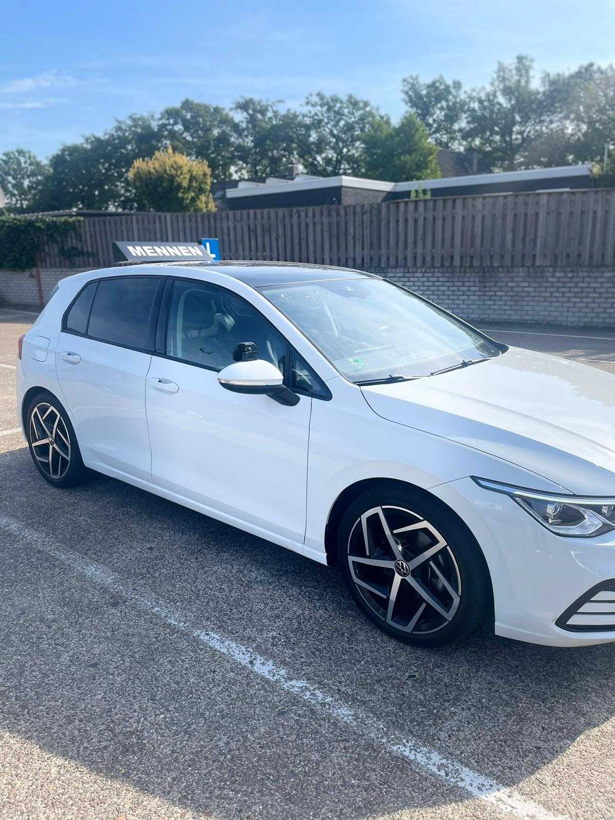 Witte Volkswagen Golf-lesauto van Mennen in de zon